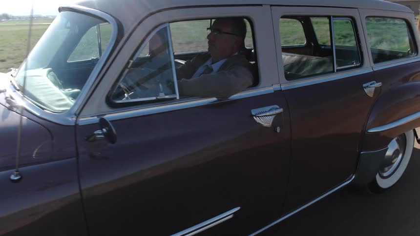 A man driving a vintage car