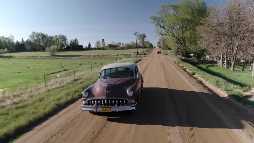 Vintage cars driving in a rural area