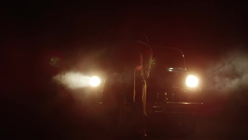 Elderly man raises the classic cars hood at night