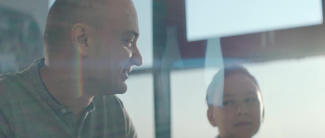 A father and son sit inside and talk