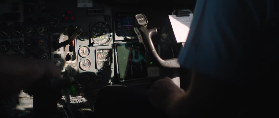 A pilot sits in the cockpit and holds on to the steering wheel