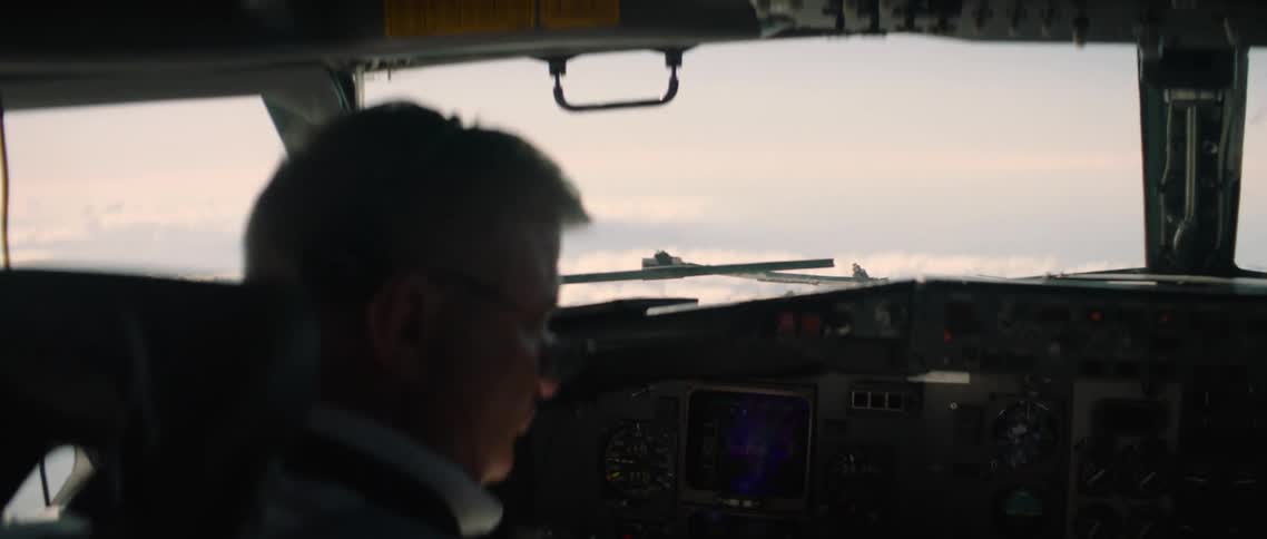 A white male sits on a cockpit and pilots an aircraft