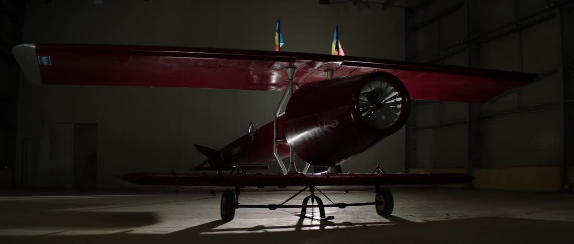 The plane is parked in the dark hangar