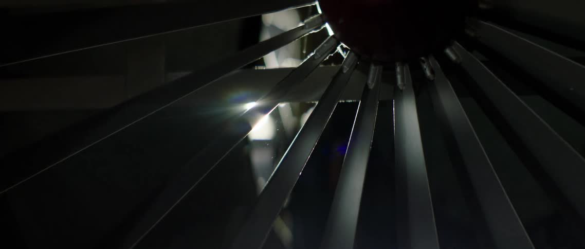 A flashlight is shone through the blades of a jet turbine