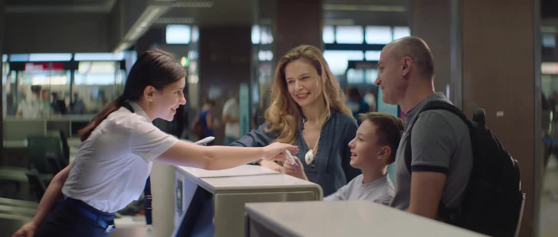 A family gets tickets from an agent at the airport