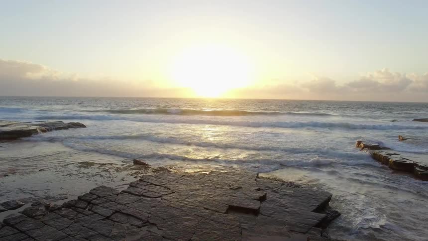 View of the sun setting on a rocky coast