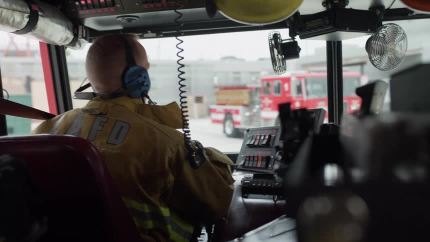 A firefighter is driving to the scene