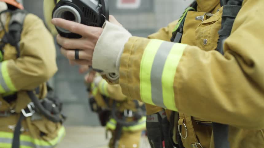 The fireman gear up by the burning building
