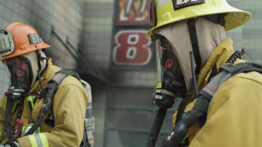 Firefighters inside a building putting on their gloves