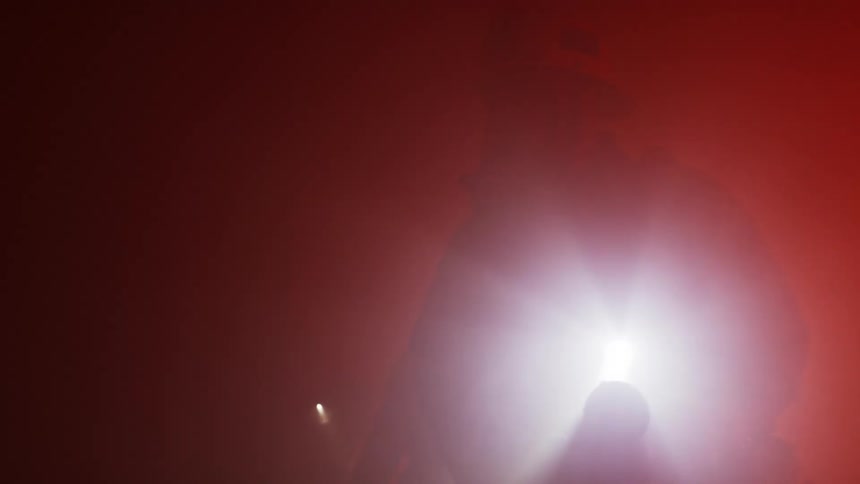Firefighters search inside a building with flashlights
