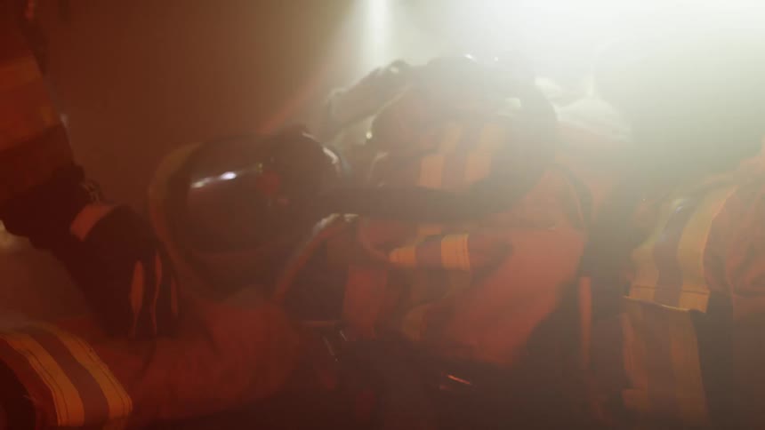 Two firefighters assist a fallen firefighter