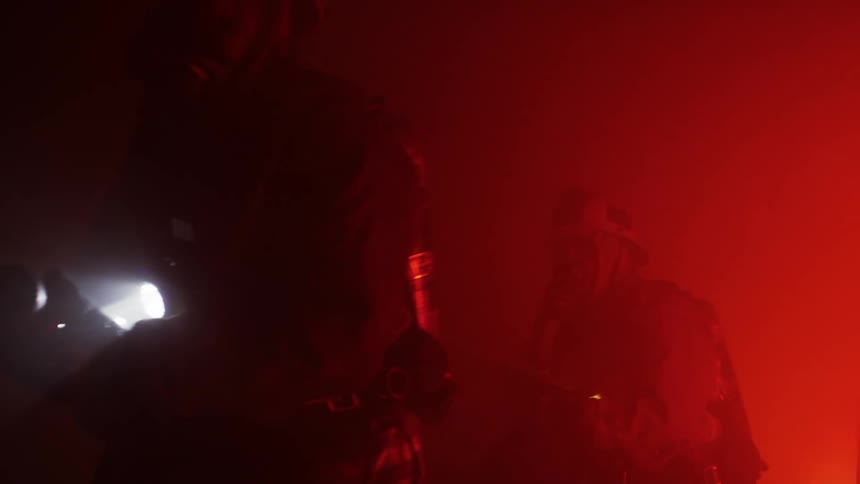 Firefighters use flashlights to walk through heavy smoke