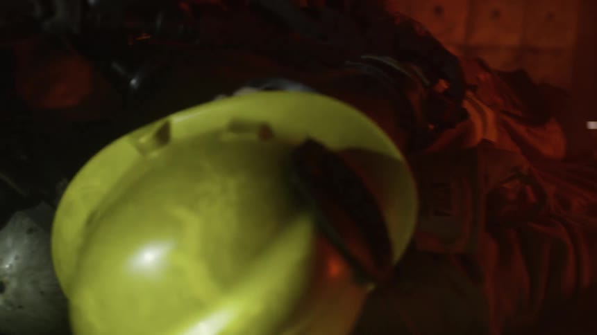 A downed firefighter is dragged across the floor