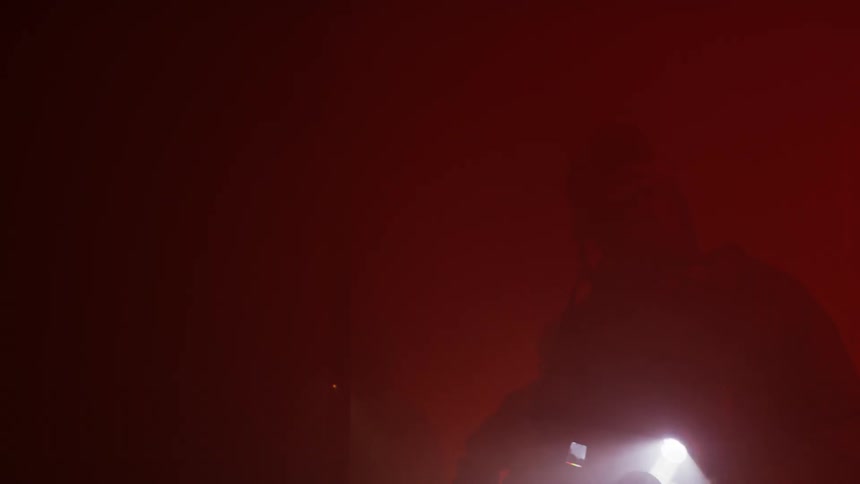 Firefighters search around with flashlights in the thick smoke