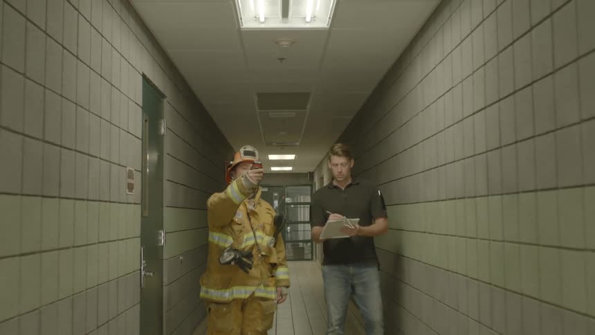 A firefighter tells a building inspector to look up at the ceiling