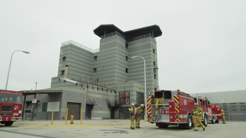 Firefighters grabbing their gear off a firetruck