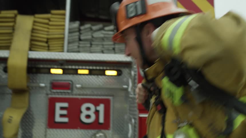 Firemen are responding to a scene in a city