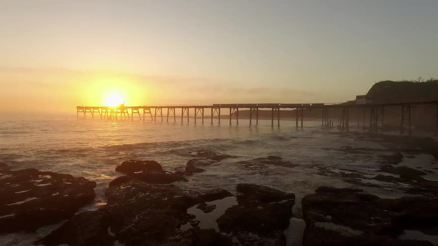 Sunrise over long ocean pier