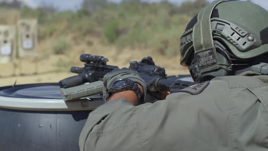 A military police fires his rifle at a shooting range
