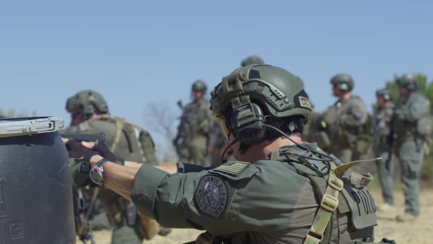 Military police shooting guns at a shooting range