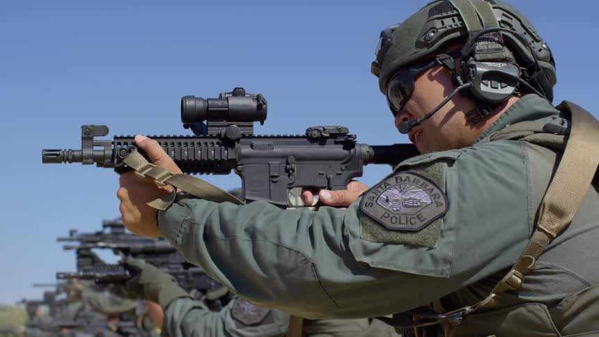 A group of military police shoot guns at a shooting range