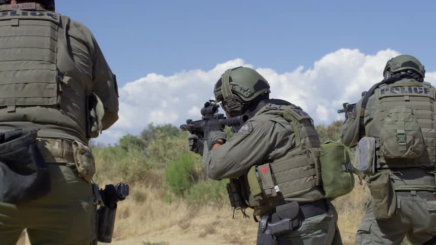 Police in combat gear shoot assault rifles on a training exercise