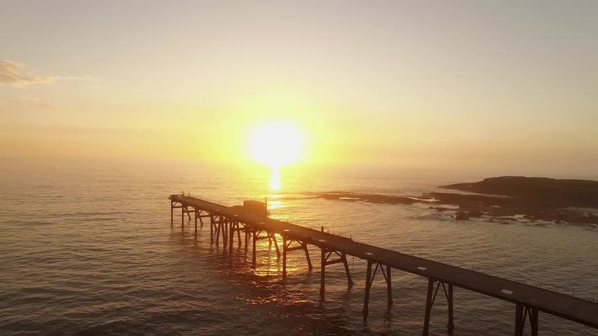 Sun setting over an ocean pier
