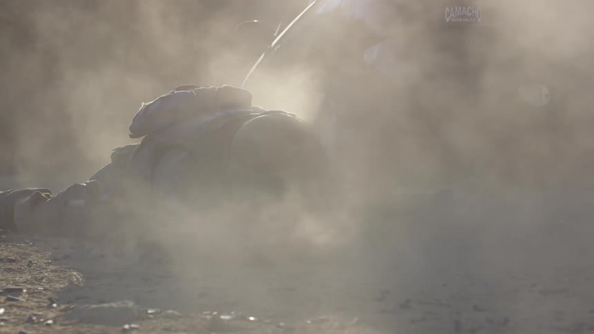 A soldier lies on the ground and shoots his gun