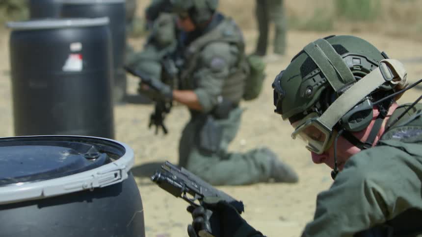 Military police shooting their guns at a shooting range