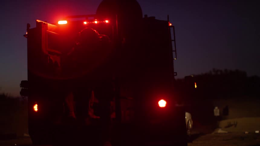 Two firefighters get out of a truck at the scene of an accident
