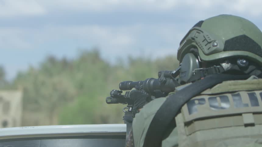 A military police fires a gun