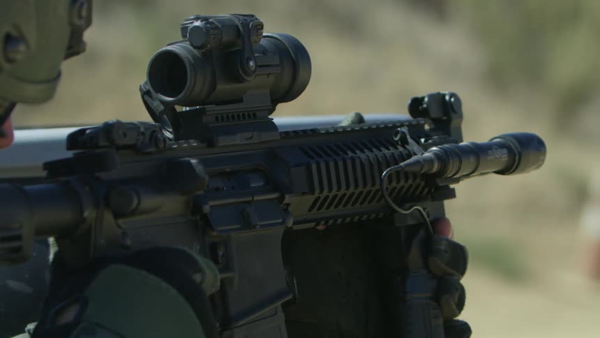 A soldier fires his rifle outside