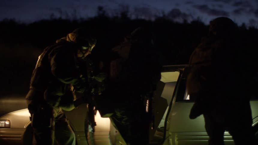 The soldiers check the car before walking back