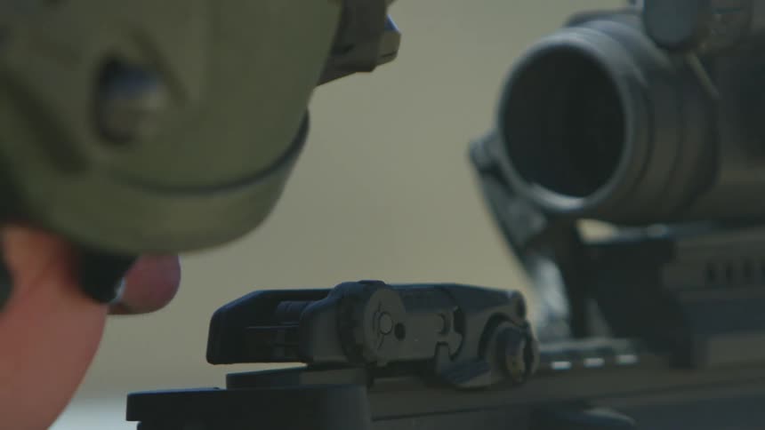 A soldier fires his rifle