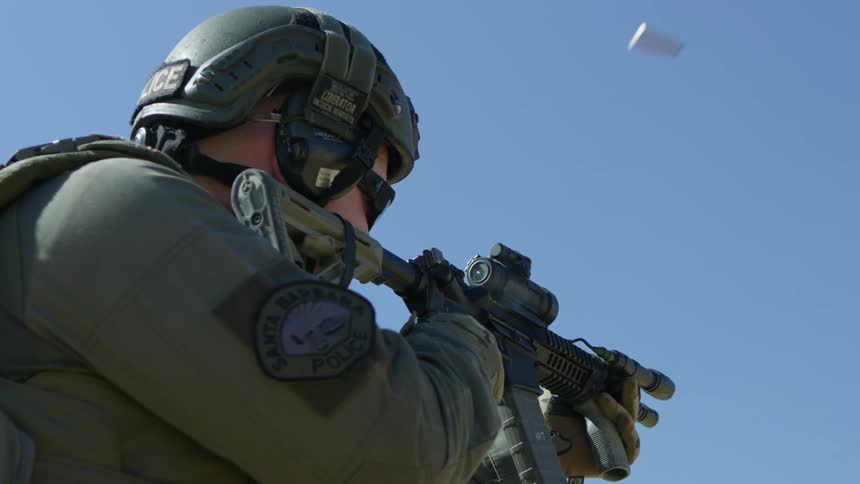 A soldier is firing his rifle on a sunny day