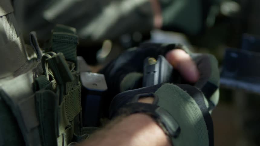 A soldier loads his gun
