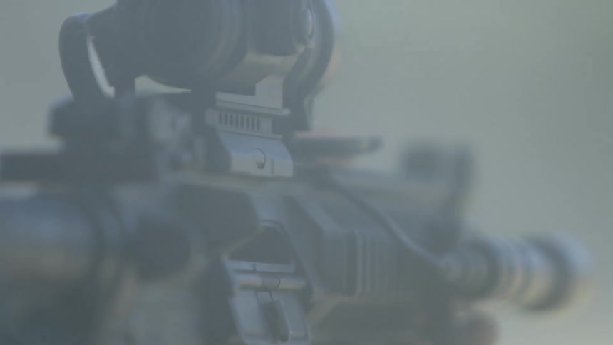 Smoke fills the sky as a long gun fires bullets toward a target
