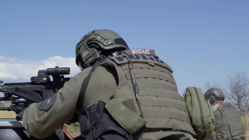 Police officers in military uniform take cover in a training exercise