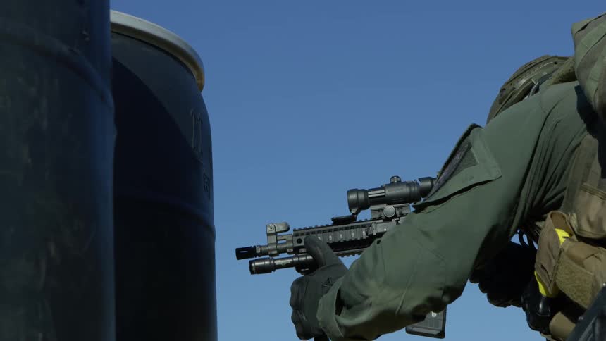 Police officer in military gear shoots an assault rifle on a training exercise