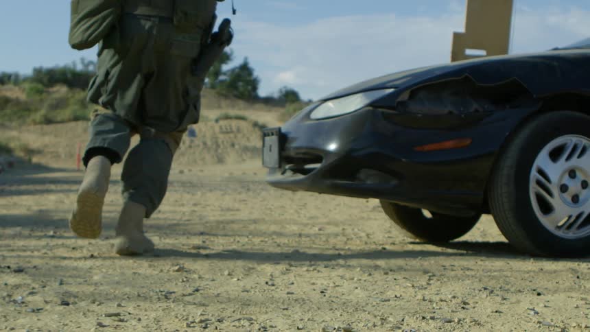 Man runs around the front of a car under a blue sky