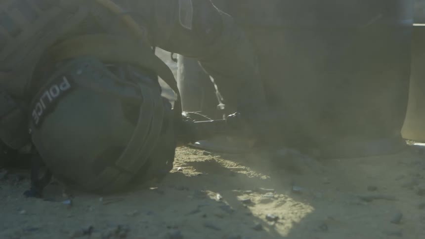 A soldier lies on the ground and shoots his gun
