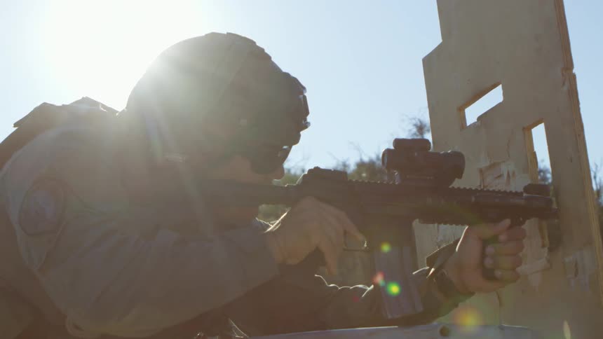 A police officer practices shooting in an open field
