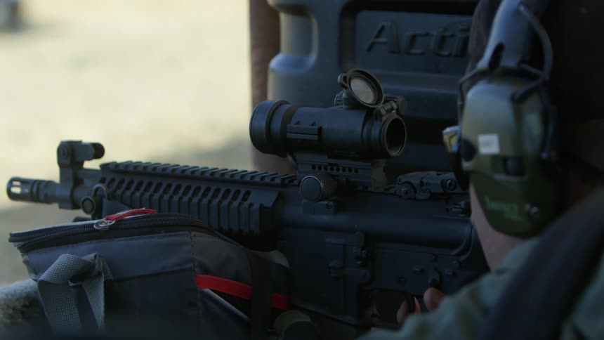 A military police fires a rifle