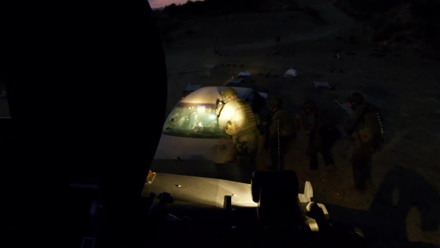 Police officers in military gear on a training exercise at sunset