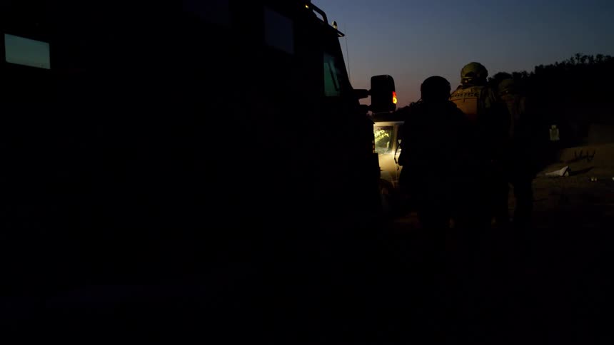 A group of heavily armed cops walk up to a vehicle and fire rounds through the window