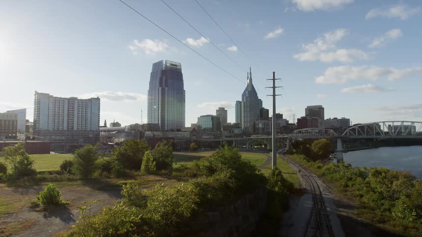 Railroad tracks run by a park in a city