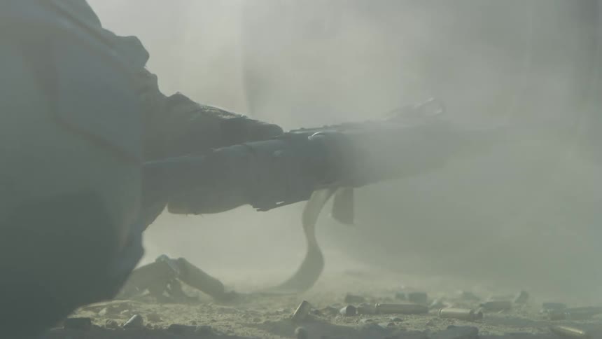 A soldier down on the ground shoots a gun
