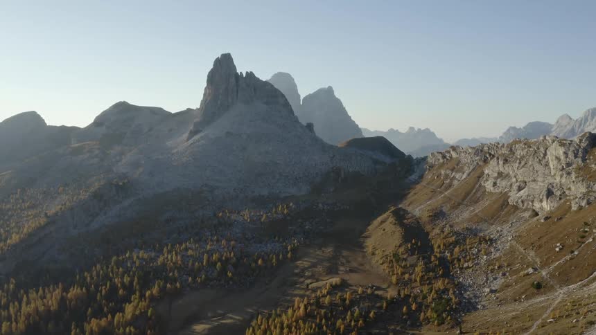 Aerial view of peaks and cliffs of mountain range at sunset