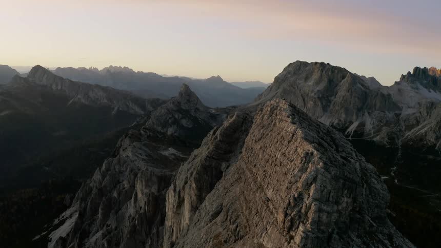 Aerial view of peaks and cliffs on a mountain range at sunset