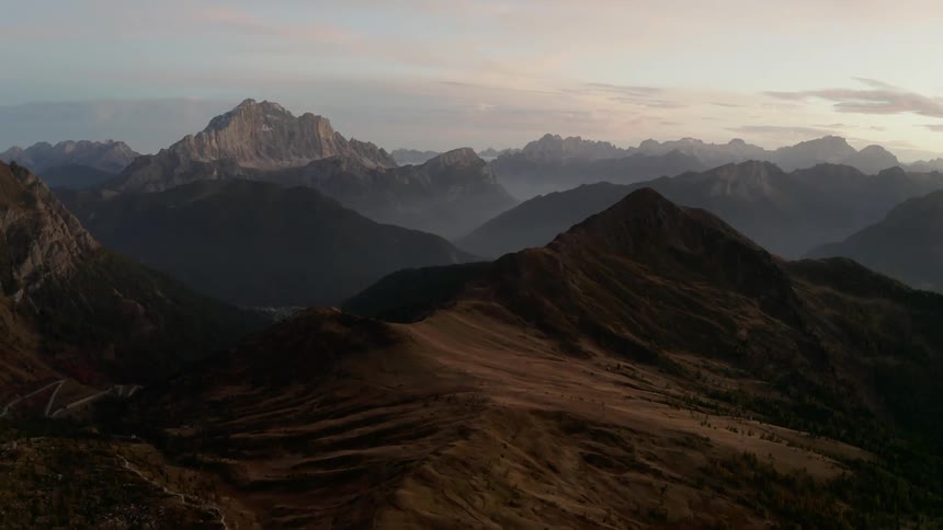 The sun sets over a canyon filled with peaks and valleys of varying size